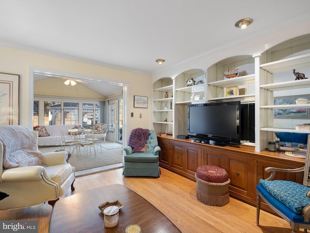 living room featuring ornamental molding, light wood-type flooring, and built in shelves