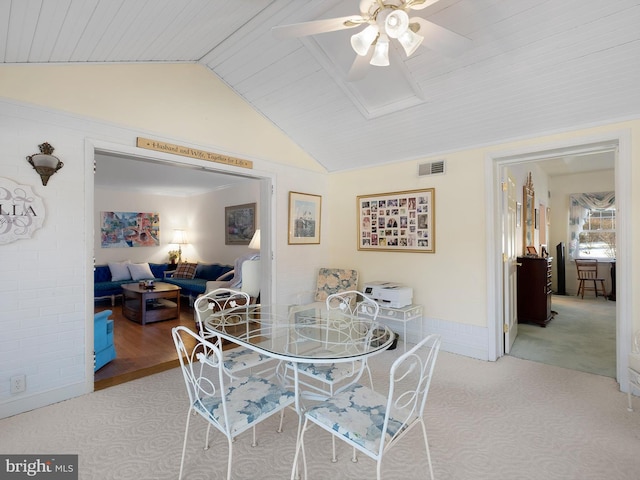 dining room featuring lofted ceiling, light carpet, and ceiling fan