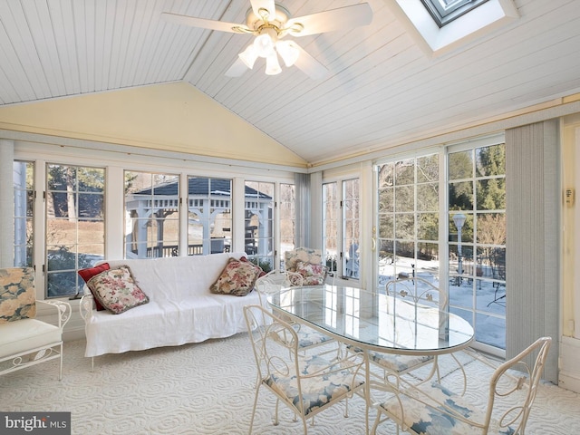 sunroom / solarium with ceiling fan, vaulted ceiling with skylight, and wooden ceiling