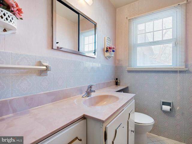 bathroom with vanity, a wealth of natural light, tile walls, and toilet