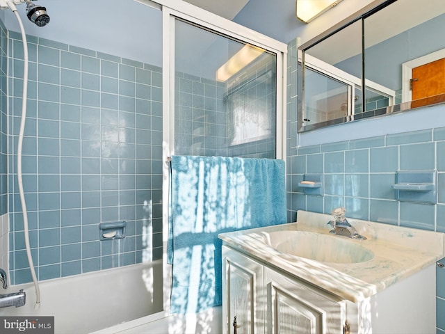 bathroom with tile walls, backsplash, tiled shower / bath combo, and vanity