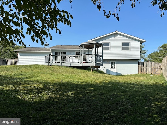 rear view of house featuring a yard and a deck