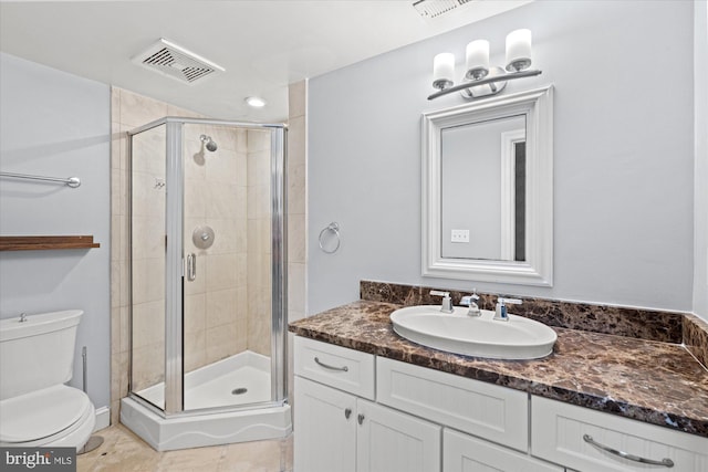 bathroom featuring toilet, tile patterned flooring, an enclosed shower, and vanity