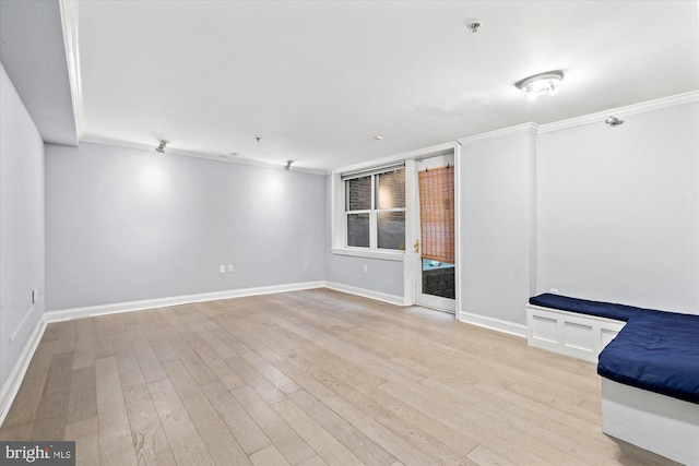 unfurnished living room featuring light wood-type flooring and ornamental molding