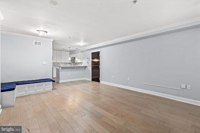 unfurnished living room featuring light hardwood / wood-style floors and ornamental molding