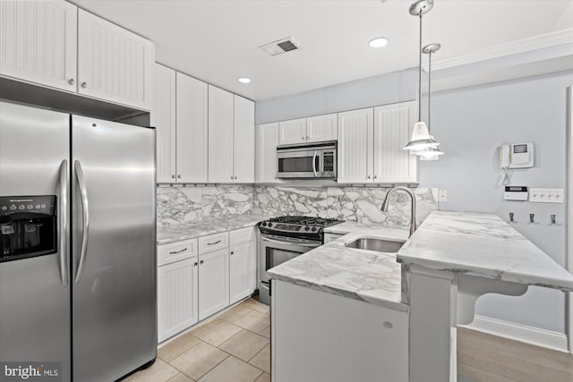 kitchen with white cabinets, decorative light fixtures, appliances with stainless steel finishes, and sink