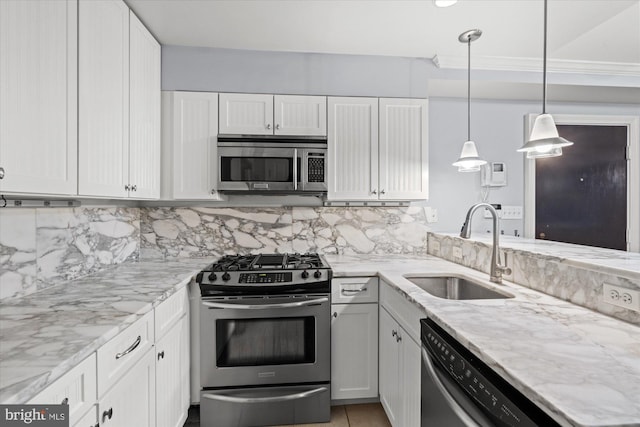 kitchen featuring pendant lighting, appliances with stainless steel finishes, white cabinetry, sink, and light stone counters