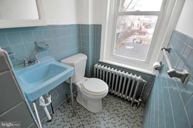 bathroom featuring plenty of natural light, toilet, radiator, and tile patterned floors