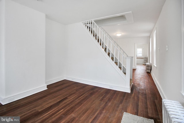 staircase featuring radiator and hardwood / wood-style floors