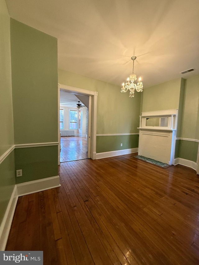 interior space with dark hardwood / wood-style floors and ceiling fan with notable chandelier