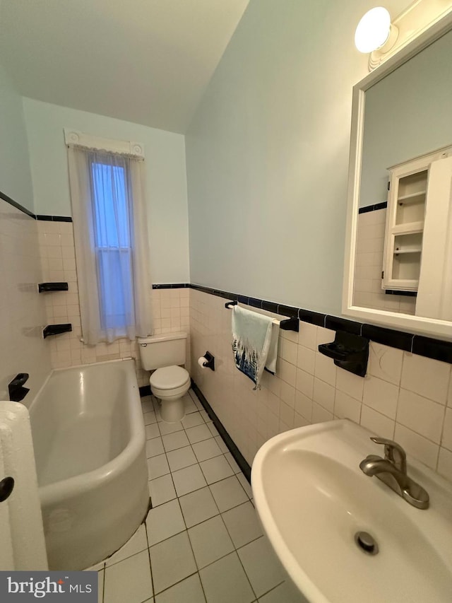 bathroom featuring sink, tile walls, vaulted ceiling, tile patterned floors, and toilet