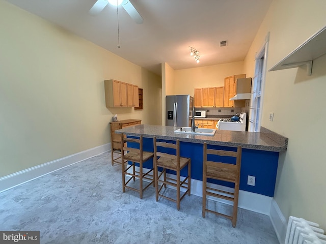 kitchen featuring radiator, white appliances, sink, decorative backsplash, and kitchen peninsula