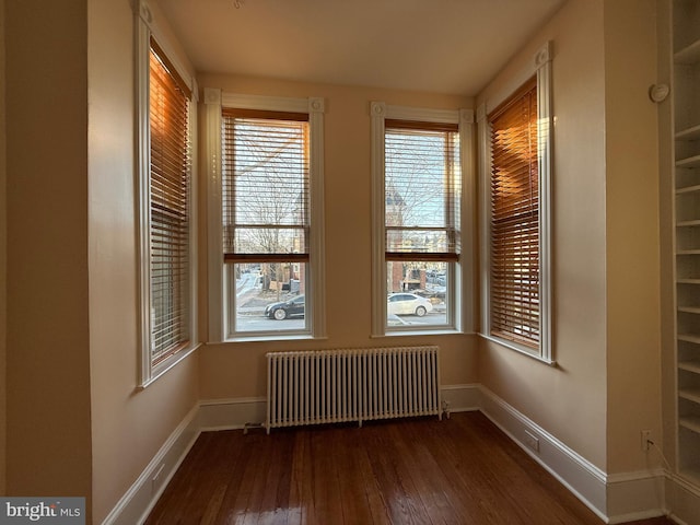 spare room with radiator and dark hardwood / wood-style floors