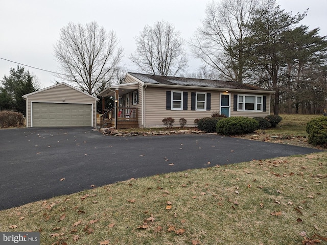 single story home featuring an outbuilding, a garage, and a front lawn