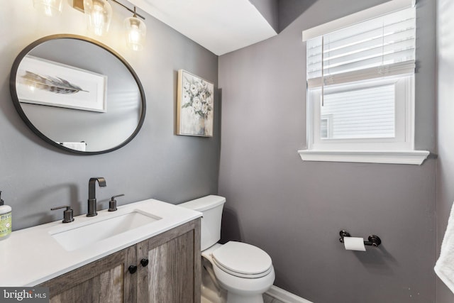 bathroom featuring plenty of natural light, toilet, and vanity