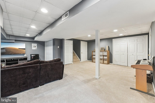 carpeted living room with a drop ceiling