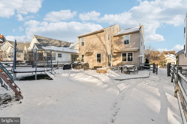 snow covered property with a trampoline