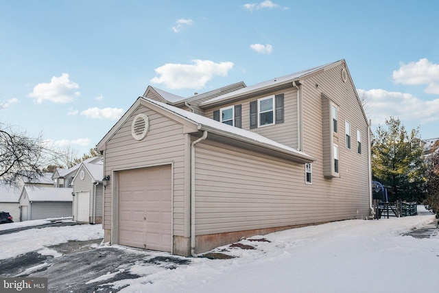 snow covered property with a garage