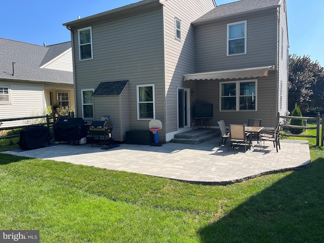 rear view of house with a lawn and a patio