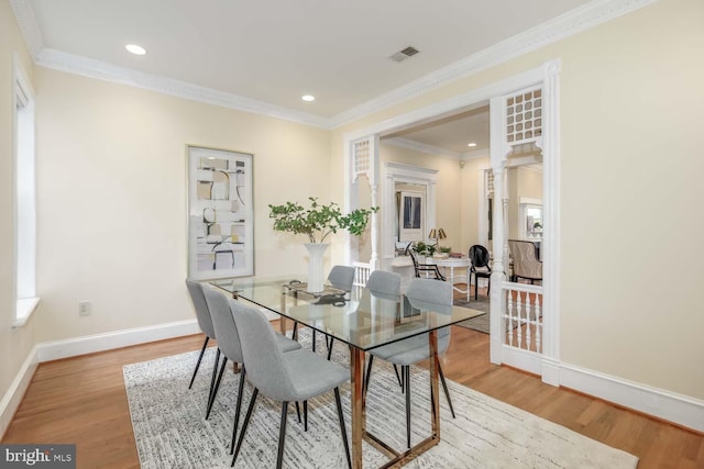 dining space with crown molding, hardwood / wood-style flooring, and a wealth of natural light