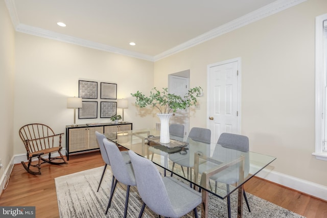 dining room with wood-type flooring and crown molding