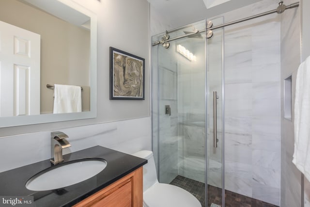 bathroom featuring vanity, a shower with door, tile walls, and toilet