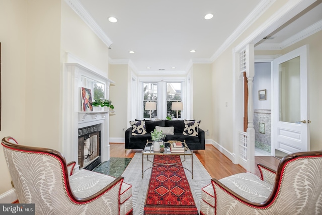 living room with light wood-type flooring and ornamental molding