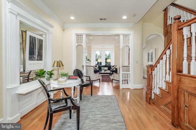 foyer entrance with crown molding and light hardwood / wood-style floors