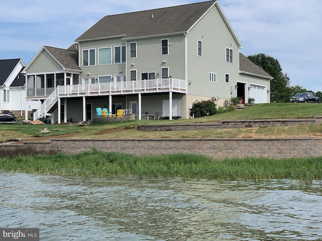 rear view of property featuring a yard, a sunroom, and a water view