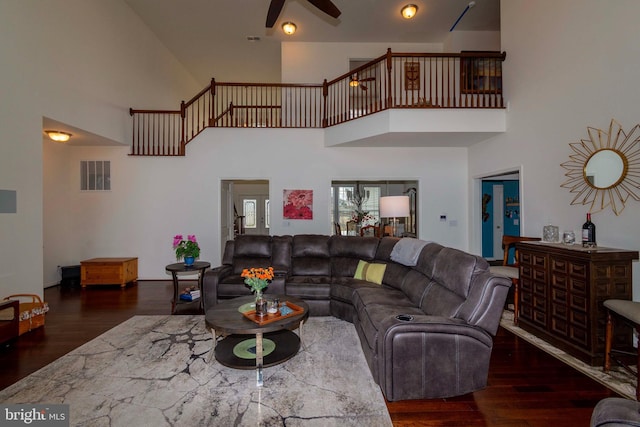 living room featuring dark wood-type flooring and ceiling fan