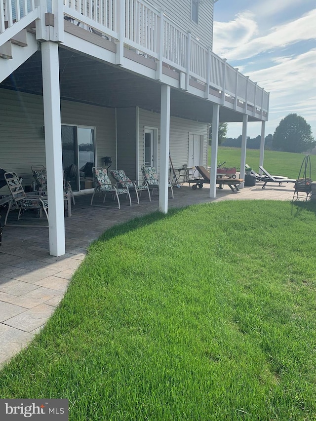 view of yard with a wooden deck and a patio