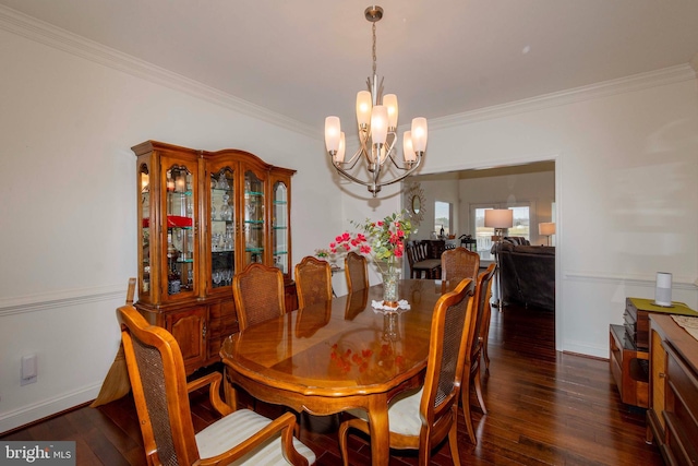 dining space featuring dark hardwood / wood-style flooring, crown molding, and an inviting chandelier