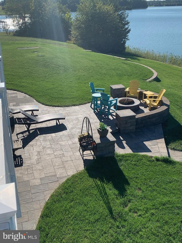 view of yard featuring a fire pit, a patio, and a water view