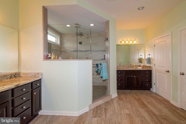 bathroom featuring hardwood / wood-style flooring, vanity, and an enclosed shower