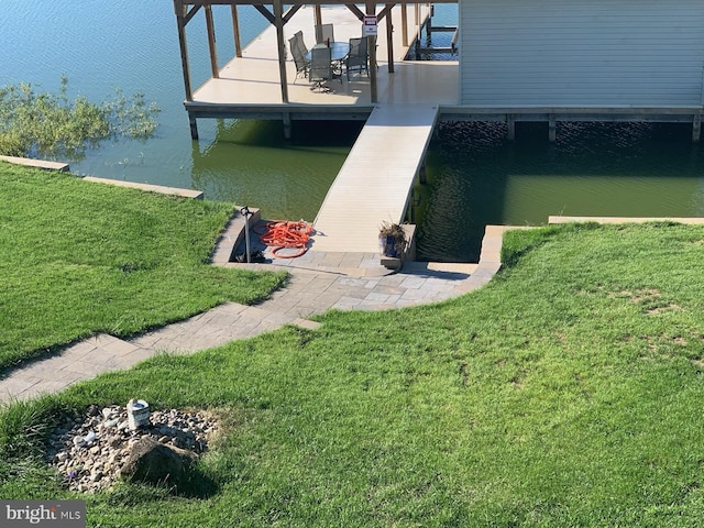 view of dock with a water view and a lawn