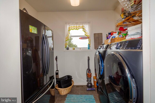 laundry room featuring washer and dryer and dark tile patterned floors