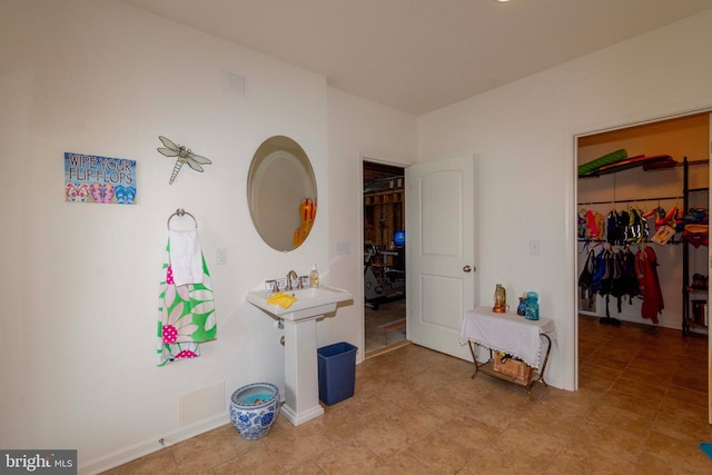 bedroom featuring a spacious closet, sink, and a closet