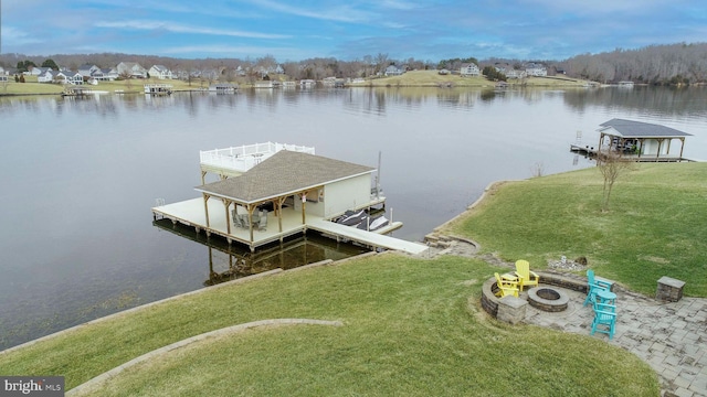 dock area with a water view, a yard, and a fire pit