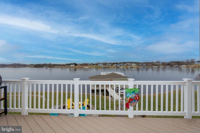 deck with a water view and a yard