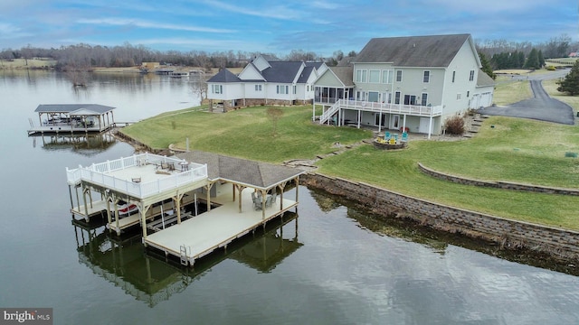 dock area featuring a deck with water view and a yard