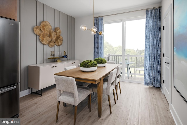 dining room with light hardwood / wood-style floors and an inviting chandelier