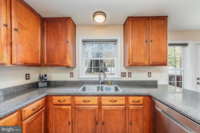 kitchen with dishwasher, brown cabinetry, and a sink