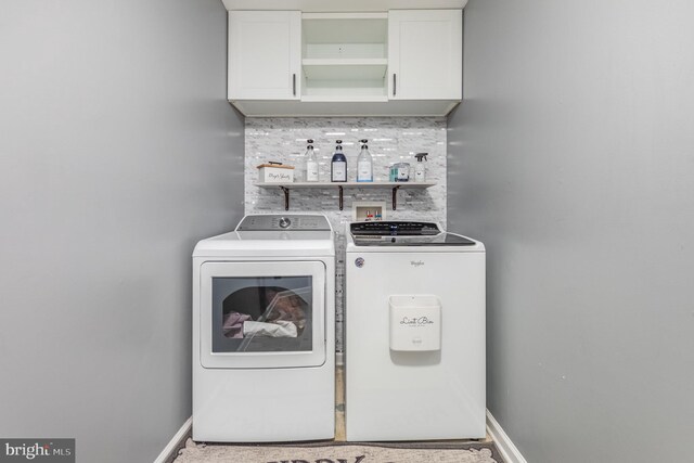 laundry area featuring cabinet space, washing machine and dryer, and baseboards