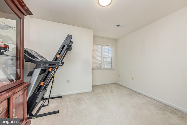 exercise room with light colored carpet, visible vents, and baseboards