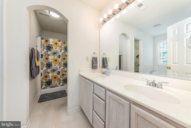 full bath with double vanity, visible vents, and a sink