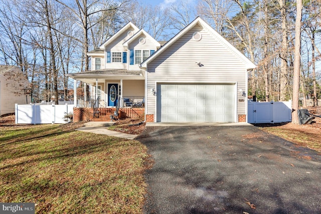 view of front of property featuring a garage, a front lawn, and a porch