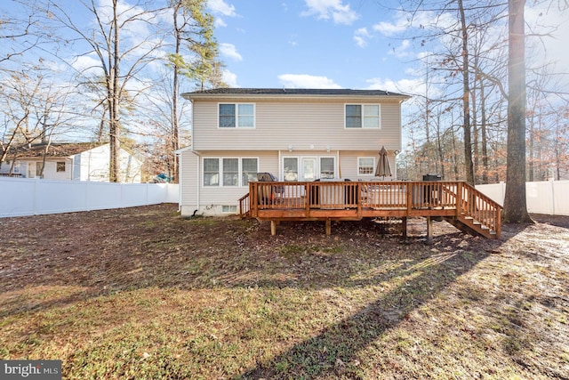 rear view of property featuring a wooden deck and a fenced backyard