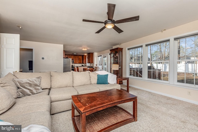 living room with light colored carpet, baseboards, and ceiling fan