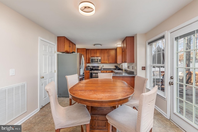 dining space featuring light tile patterned flooring, visible vents, and baseboards