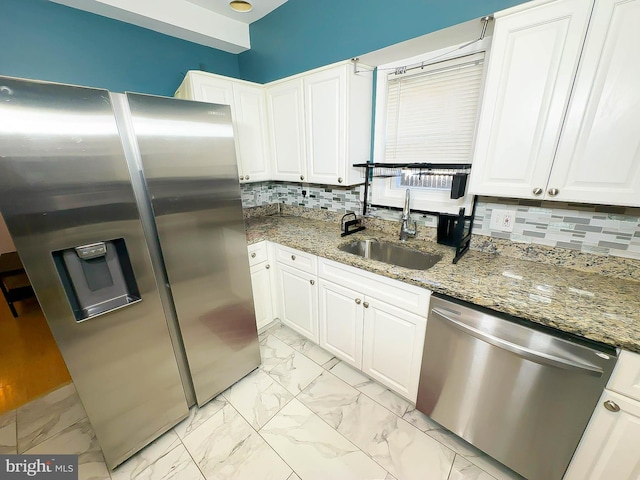 kitchen featuring sink, white cabinetry, tasteful backsplash, stainless steel appliances, and light stone countertops